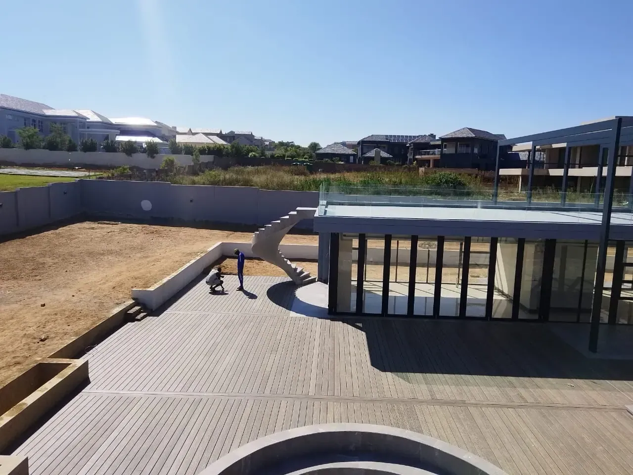 Timber deck and spiral staircase being installed at a modern home